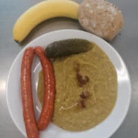 Fotografie jídla Hrachová kaše, opečená uzenina, smažená cibulka, sterilovaná okurka, pečivo