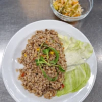 Fotografie jídla Pohankové rizoto (mrkev, kukuřice, paprika, hrášek, lněné semínko, houby), zeleninový salát